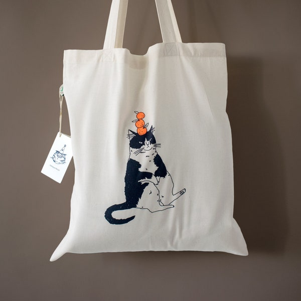 Orange Cat tote bag | Hand screen printed illustration of a cat balancing oranges on natural organic cotton bag with navy and neon orange