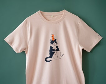 -shirt chat orange | Illustration sérigraphiée à la main d'un chat portant des oranges sur un t-shirt en coton bio rose brumeux, bleu marine et orange