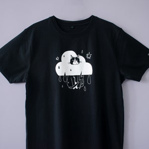 Camiseta Rain Cloud Cat / Serigrafía manual sobre camiseta de algodón orgánico negra con ilustración blanca de un gato disfrazado y nada divertido