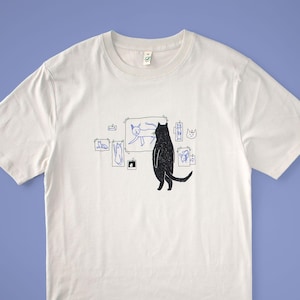 Cat gallery t-shirt | Hand screen printed on beige organic cotton tee with black and blue illustration of a cat judging cat art