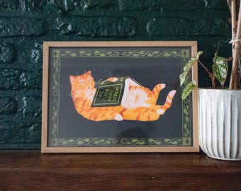 Comer, dormir, ler, repetir | Impressão artística Giclée para amantes de livros, retratando um gato laranja sonolento com um livro na barriga.