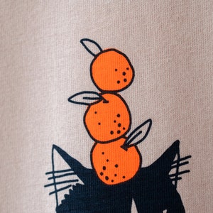 Oranje Kat t-shirt Met de hand gezeefdrukte illustratie van een kat die sinaasappels balanceert op een mistig roze T-shirt van biologisch katoen met marineblauw en oranje afbeelding 7