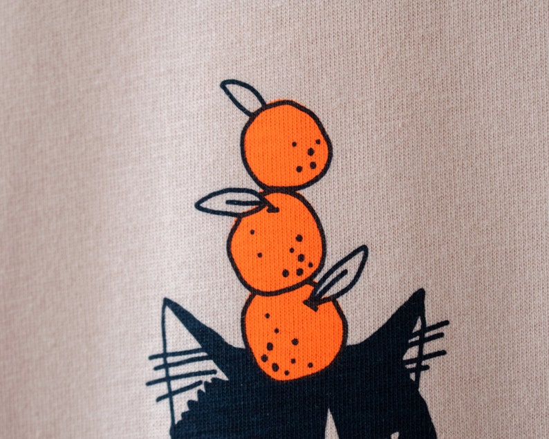 Oranje Kat t-shirt Met de hand gezeefdrukte illustratie van een kat die sinaasappels balanceert op een mistig roze T-shirt van biologisch katoen met marineblauw en oranje afbeelding 7
