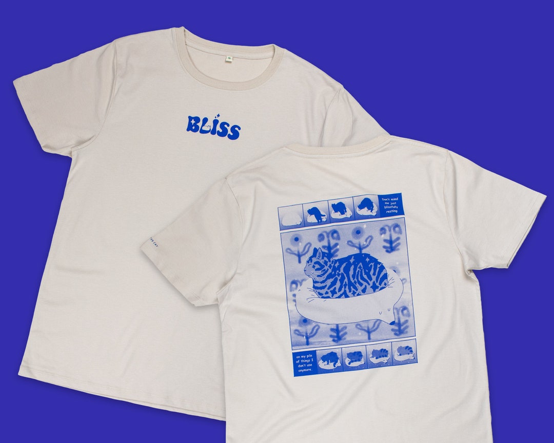 Bliss t-shirt | Hand screen printed on sand/beige organic cotton tee with blue comic style illustration of a tabby cat getting comfy
