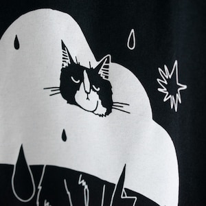 Rain Cloud Cat T-Shirt Hand screen printed on black organic cotton tee with white illustration of a not amused cat in a costume image 6