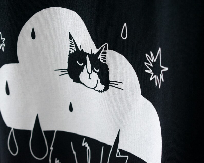 Rain Cloud Cat T-Shirt Hand screen printed on black organic cotton tee with white illustration of a not amused cat in a costume image 6