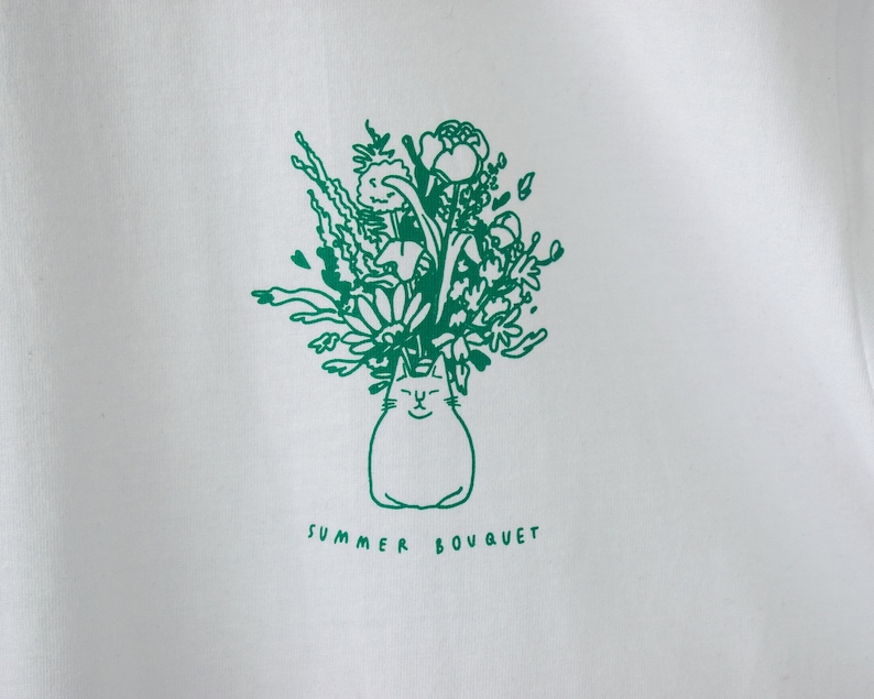 Zomerboeket T-shirt Handgezeefdrukte illustratie van 7 katten met bloemenkronen en andere planten in het groen op een wit T-shirt van biologisch katoen afbeelding 3