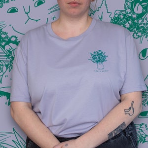 -shirt bouquet d'été | Illustration sérigraphiée à la main de 7 chats avec des couronnes de fleurs et d'autres plantes en vert sur un t-shirt en coton biologique lilas
