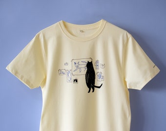 T-shirt Cat Gallery / Serigrafata a mano su maglietta in cotone organico ecru/giallo chiaro con illustrazione in nero e blu di un gatto che giudica l'arte del gatto