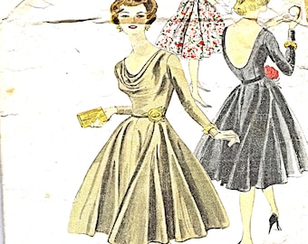May include: Vintage Vogue sewing pattern number 9825 for a dress. The pattern is for sizes 20-40 bust. The image shows three women wearing different styles of dresses. The woman in the center is wearing a brown dress with a cowl neck and a belt. The woman on the left is wearing a floral dress with a scoop neck. The woman on the right is wearing a black dress with a scoop neck and a low back.