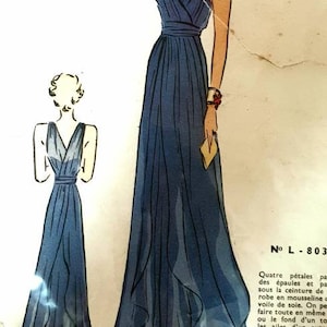 Pode incluir: Um padrão de costura vintage para um vestido de noite azul com decote em V e um corpete cruzado. O padrão é de Les Patrons de Luxe, Du Jardin des Modes, e é numerado L-803. O preço é de 8 francos franceses.