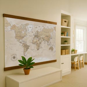 Peut inclure: Une grande carte du monde imprimée avec une esthétique vintage, montée sur un cadre en bois. La carte présente des informations géographiques détaillées dans des tons beige et marron. Une petite plante en pot est placée en dessous.