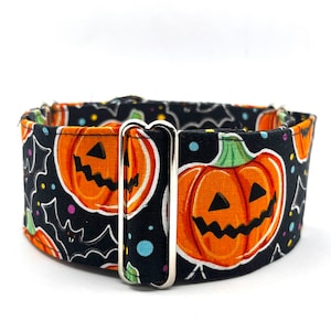 May include: A Halloween dog collar with a black fabric patterned with orange pumpkins, white bats, and colourful dots. The collar has a silver metal buckle. The collar is designed for a comfortable fit.