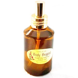Könnte beinhalten: Eine braune Glasflasche Body Begood Deodorizing Body Mist mit einem goldfarbenen Sprühkopf. Auf dem Etikett steht "Body Begood" und "PEACE OUT". Die Flasche ist mit einer klaren Flüssigkeit gefüllt.