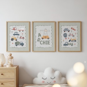 May include: Three framed wall art prints featuring light green and white vertical stripes. The prints display illustrations of various vehicles including a helicopter, ambulance, tractor, crane, police car, bicycle, hot air balloon, and truck, with the name ARCHIE.