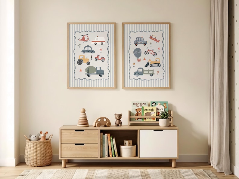 May include: Two framed wall art prints featuring illustrations of various vehicles including a helicopter, ambulance, tractor, police car, and construction equipment, displayed in light wood frames above a wooden storage unit with toys and books.