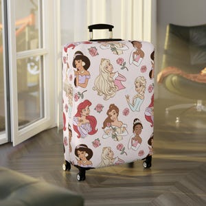 May include: A rolling suitcase with a light pink cover, decorated with cartoon illustrations of princesses and pink roses. The princesses are shown with different hairstyles and outfits. The suitcase has a black handle and wheels.