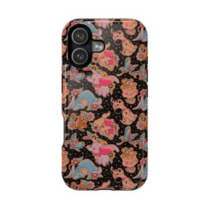 May include: A black phone case featuring a repeating pattern of cartoon characters, including Dumbo the elephant, a dalmatian, and a monkey. The design incorporates flowers and stars in shades of pink, blue, and tan.