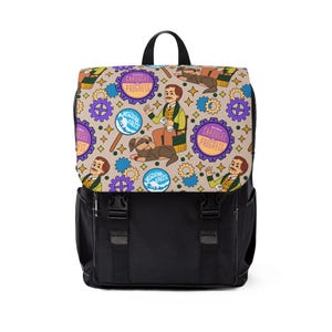 Op de afbeelding: Zwarte rugzak met een flap met een herhalend patroon van stripfiguren, tandwielen en tekst. De rugzak heeft een zwarte basis, verstelbare bandjes en een handvat aan de bovenkant. De flap heeft een beige achtergrond met kleurrijke illustraties.