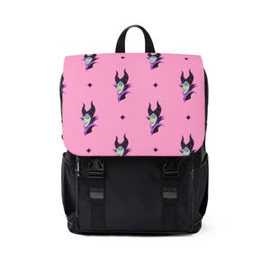 Op de afbeelding: Zwarte rugzak met een roze flap met een herhaald patroon van een stripfiguur met hoorns en een paarse kraag. De rugzak heeft een zwart handvat, riemen en gespen.