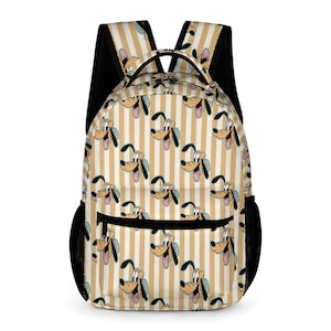 Puede incluir: Una mochila con un patrón repetido de la cara de un perro de dibujos animados sobre un fondo a rayas crema y beige. La mochila tiene bolsillos laterales de malla negra y correas negras para los hombros. Un bolsillo negro con cremallera está en la parte delantera.