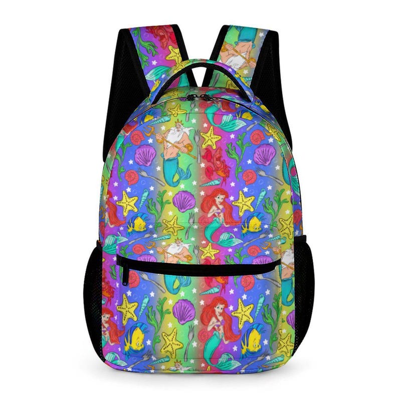 May include: A colorful backpack featuring a repeating pattern of cartoon mermaids, starfish, shells, and fish on a rainbow background. The backpack has black mesh side pockets and straps, and a front zippered pocket.