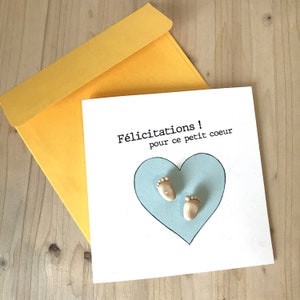Tarjeta de nacimiento con sobre amarillo y alfileres de pies de bebé de fimo