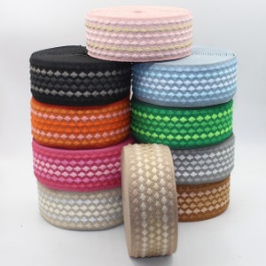 May include: A stack of ten elastic bands in various colours and patterns. The bands feature a diamond-shaped design and are made from a soft, stretchy material.
