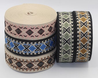 Könnte beinhalten: Vier Rollen gewebter Besatz mit geometrischen Mustern in Beige, Schwarz, Rosa, Blau und Grün. Der Besatz ist etwa 2,5 cm breit.