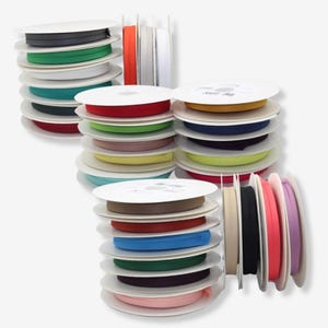 Può includere: Pile di bobine di sbieco colorato in vari colori, tra cui verde, rosso, giallo, blu e rosa. Le bobine sono disposte ordinatamente su dischi di cartone bianco, mostrando una varietà di tonalità per progetti di cucito e artigianato.