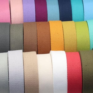 Puede incluir: Una variedad de cintas de algodón de diferentes colores, incluyendo rosa, morado, rojo, azul, verde, amarillo, naranja, blanco, beige y marrón.