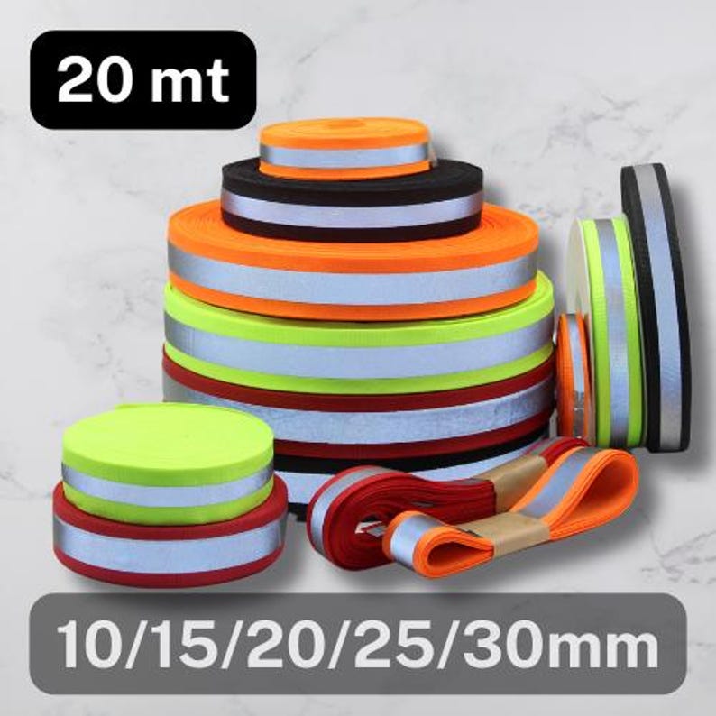 May include: Various rolls of reflective tape in multiple colors, including orange, black, red, and green. The tape has a silver reflective stripe. The image also shows the text "20 mt" and "10/15/20/25/30mm".