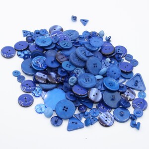 Peut inclure: Un grand tas de boutons en plastique bleu de différentes tailles et formes.