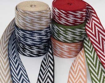 May include: Assortment of woven cotton ribbon with a chevron pattern in various colors, including beige, navy blue, red, green, and peach.