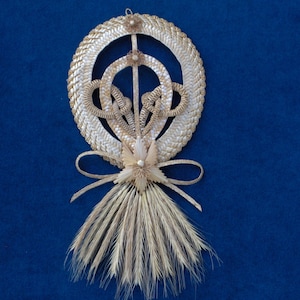 Peut inclure: Une couronne de paille avec un motif tissé et un long pompon de blé qui coule. La couronne est décorée d'un petit nœud et est un symbole traditionnel de bonne chance et de prospérité.