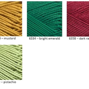 May include: Four skeins of yarn in different colors: mustard yellow, bright emerald green, dark raspberry red, and pistachio green. Each skein is labeled with a number and color name.