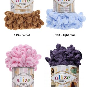 May include: Four skeins of Alize Puffy yarn in different colors: camel, light blue, powder pink, and bilberry. Each skein has a label with the Alize logo and the words "Soft & Quick" and "Puffy".