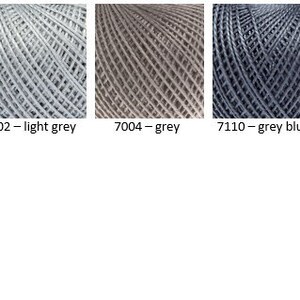 Puede incluir: Una selecci&oacute;n de ovillos de hilo en varios tonos de gris, incluyendo gris verde, gris claro, gris, gris azulado, gris oscuro y negro. El hilo se muestra sobre un fondo blanco.
