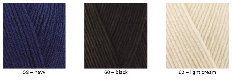 May include: Three skeins of yarn in different colours: navy blue, black, and light cream. The yarn is arranged in a diagonal pattern.