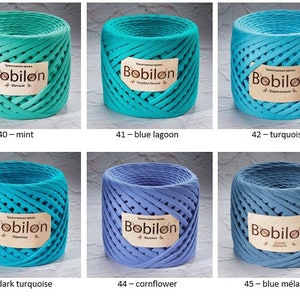 K&ouml;nnte beinhalten: Sechs Spulen Bobilon-Baumwollgarn in verschiedenen Blaut&ouml;nen und Gr&uuml;nt&ouml;nen. Die Spulen sind mit dem Farbnamen und der Nummer beschriftet. Die Farben sind: Minze, Blauer Lagune, T&uuml;rkis, Dunkelblau, Kornblume und Blau-Mix.