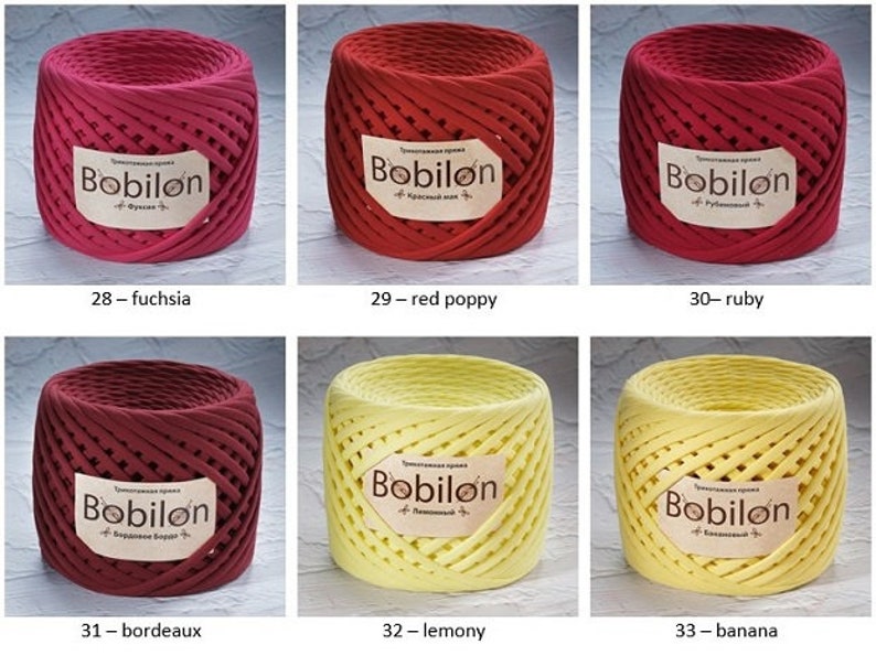 K&ouml;nnte beinhalten: Sechs Spulen mit Baumwollschnur in verschiedenen Farben, darunter Fuchsia, roter Mohn, Rubin, Bordeaux, zitronig und Banane. Jede Spule ist mit "Bobilon" und dem Farbnamen darunter beschriftet.