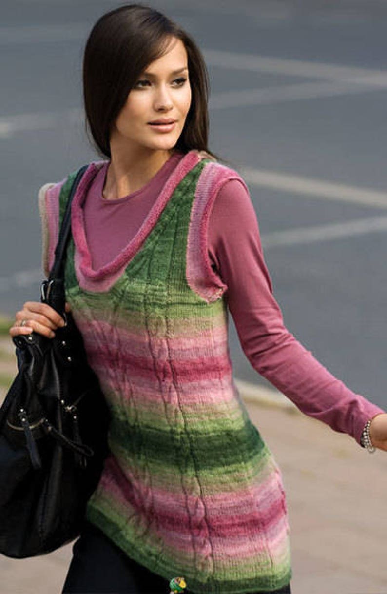 Puede incluir: Una mujer lleva un chaleco de punto a rayas rosa y verde con un dise&ntilde;o de punto de cable. Tambi&eacute;n lleva una camisa rosa de manga larga y lleva un bolso de cuero negro.