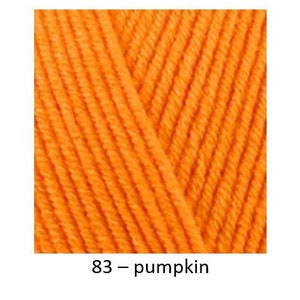 May include: Three skeins of yarn in different colours: candle light, pumpkin, and coal grey. The yarn is soft, textured, and suitable for knitting or crocheting.