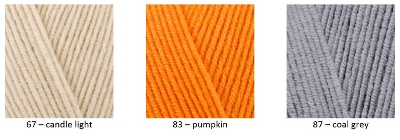 May include: Three skeins of yarn in different colours: candle light, pumpkin, and coal grey. The yarn is soft, textured, and suitable for knitting or crocheting.