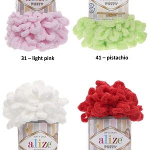 May include: Four skeins of Alize Puffy yarn in different colors: light pink, pistachio, white, and red. The yarn is soft and quick to knit with. Each skein has a label with the Alize logo and the words "Soft & Quick" and "Puffy".