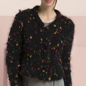 May include: A black fuzzy cardigan with a colorful confetti pattern. The cardigan has a v-neck and long sleeves.