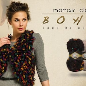 May include: A woman wearing a colorful mohair vest with a gray long-sleeved shirt. Two skeins of yarn are shown in the bottom right corner of the image. The yarn is labeled "mohair classic" and "BOHEM".