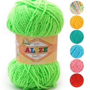 Op de afbeelding: Een bol heldergroen garen met het label "Alize Softy Baby" met een geel en rood label. Het garen is zacht en pluche, perfect voor het breien of haken van babydekens, truien en andere projecten.