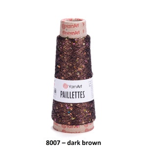 May include: A spool of dark brown yarn with iridescent sequins, labeled "YarnArt Paillettes 8007 - dark brown".