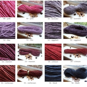 Op de afbeelding: Een verzameling van 10 bollen natuurlijke vezelgaren, geverfd in verschillende tinten roze, lavendel, lila, aubergine, donkerrood, scharlakenrood, roodbruin en zwart. Het garen wordt getoond op een vensterbank met herfstbladeren.